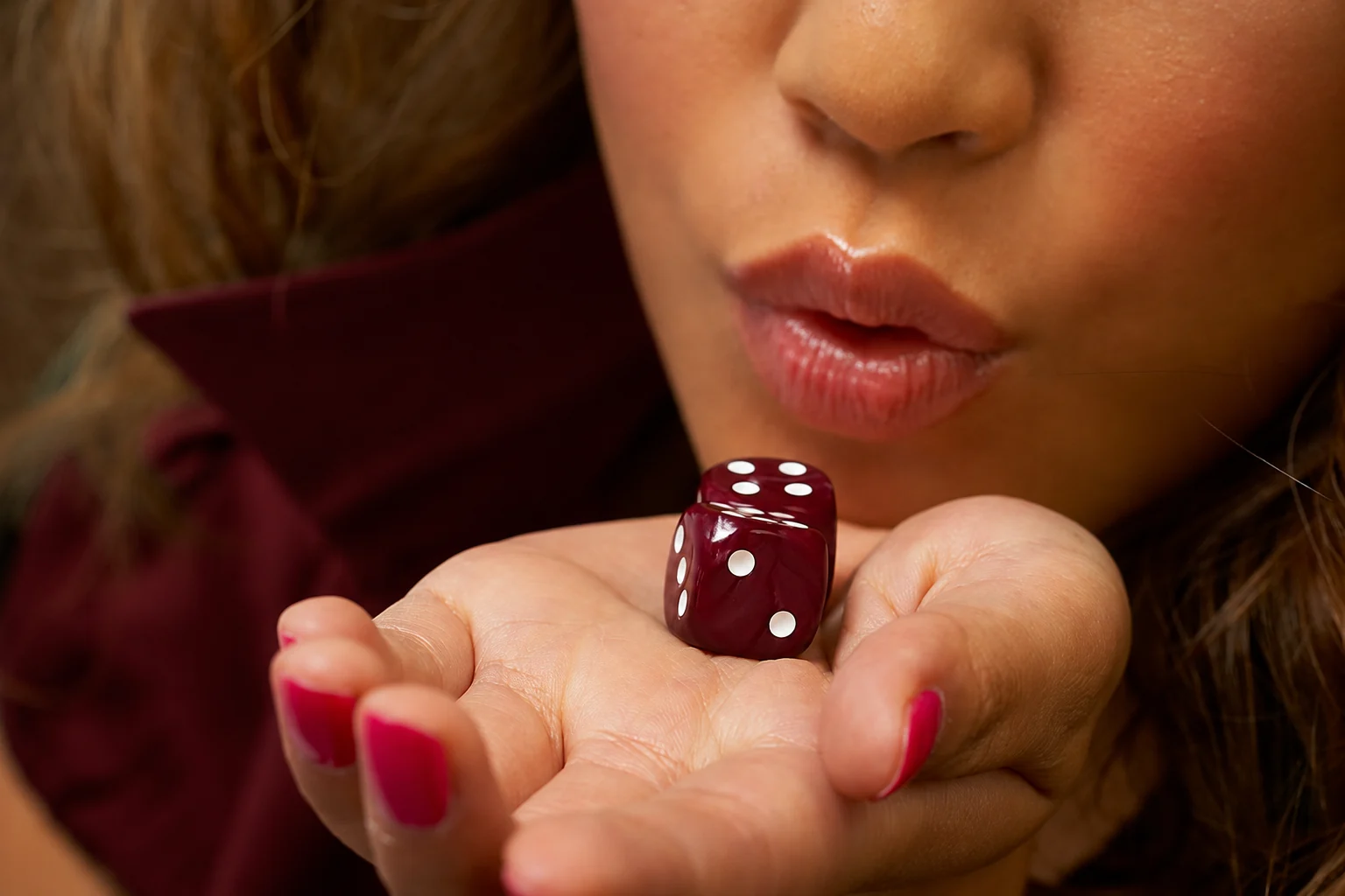 Deux dés rouges dans la main d’une invitée